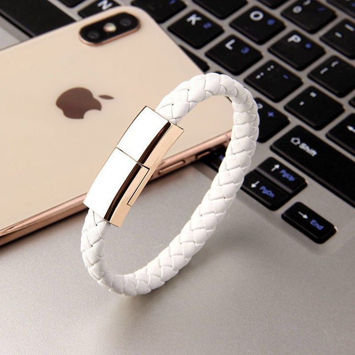White braided bracelet with gold clasp on a laptop keyboard