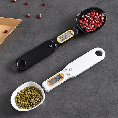 Digital measuring spoons with digital displays holding beans and peas on a gray surface.