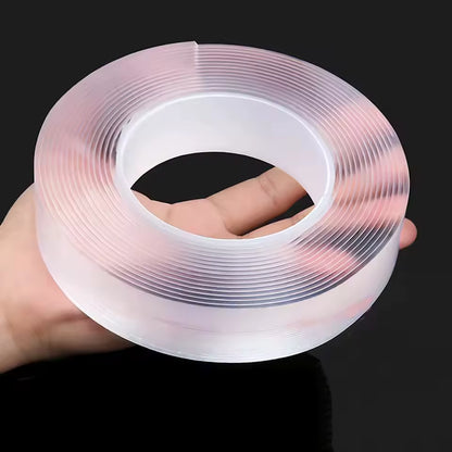 Clear adhesive tape roll held by a hand against a black background