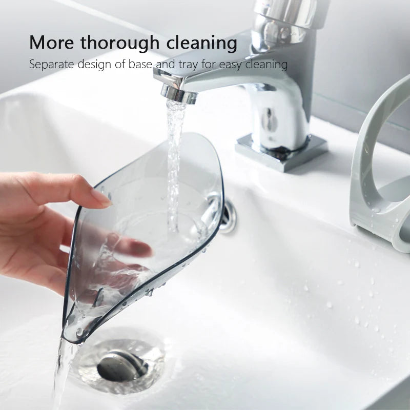 Clear glass tray being rinsed under running water in a sink with text about cleaning design.