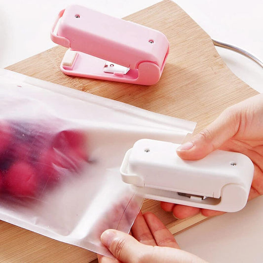 Person using a white paper punch on clear plastic sheets with a pink stapler in the background.