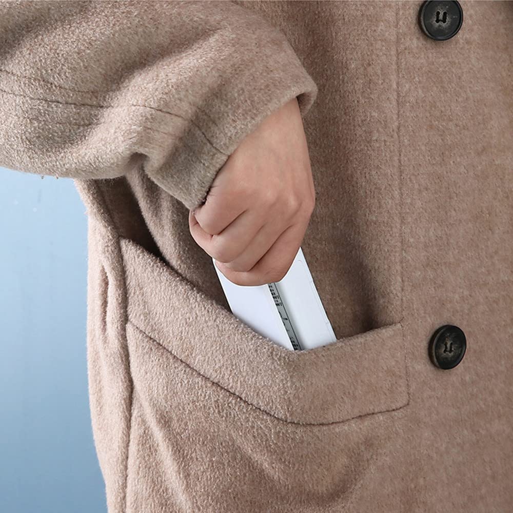 Close-up of a person wearing a beige coat with a pocket, holding a white phone.