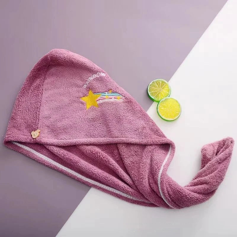 Pink towel with star and rainbow design on a white surface with lime slices.