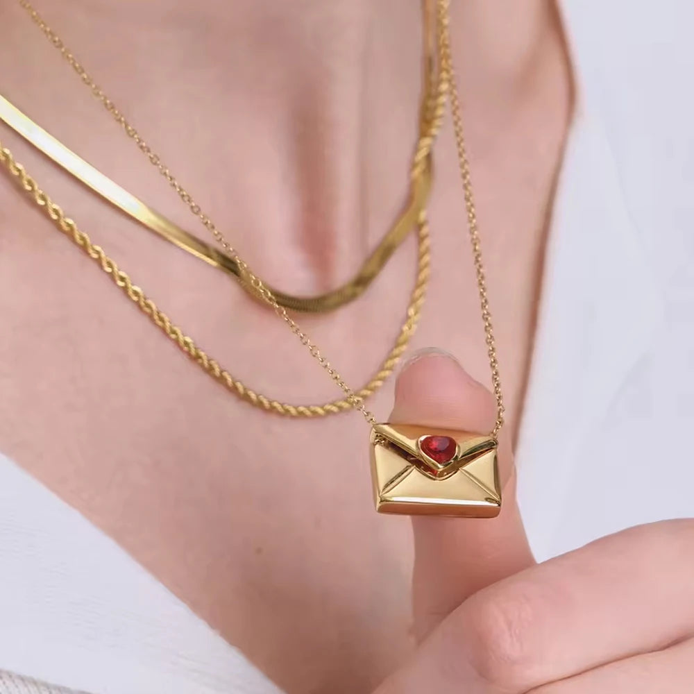 Gold necklace with a heart-shaped pendant worn by a person