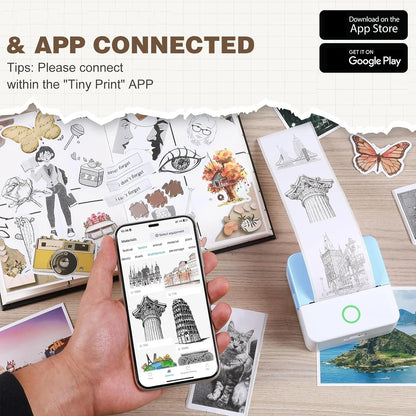 Hand holding a smartphone with an app interface, next to printed illustrations and a Tiny Print device on a wooden surface.