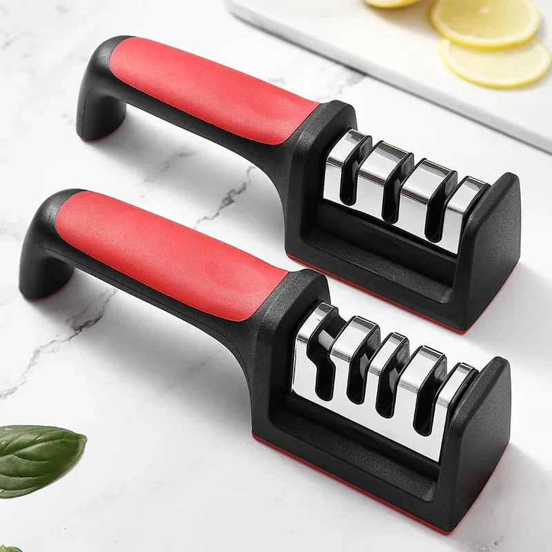 Two knife sharpener sets with red and black handles on a white marble surface.