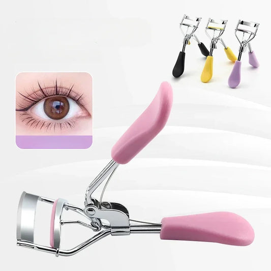 A pink and silver eyelash curler shown prominently on a white background, with a small inset of a human eye wearing curled lashes. Four additional eyelash curlers with black, yellow, and purple handles appear in the upper right.