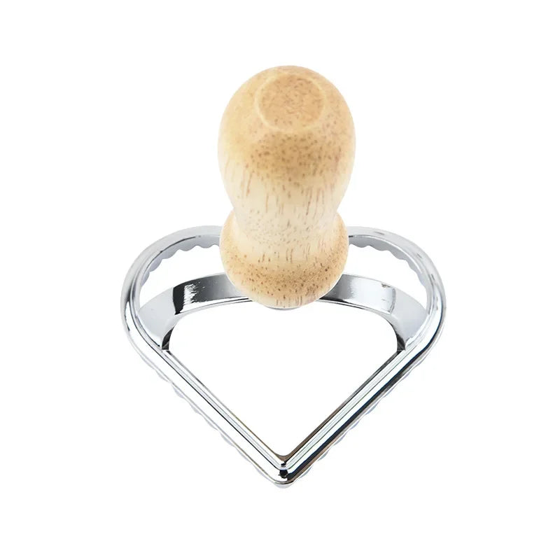 Metallic heart-shaped object with a wooden handle on a white background