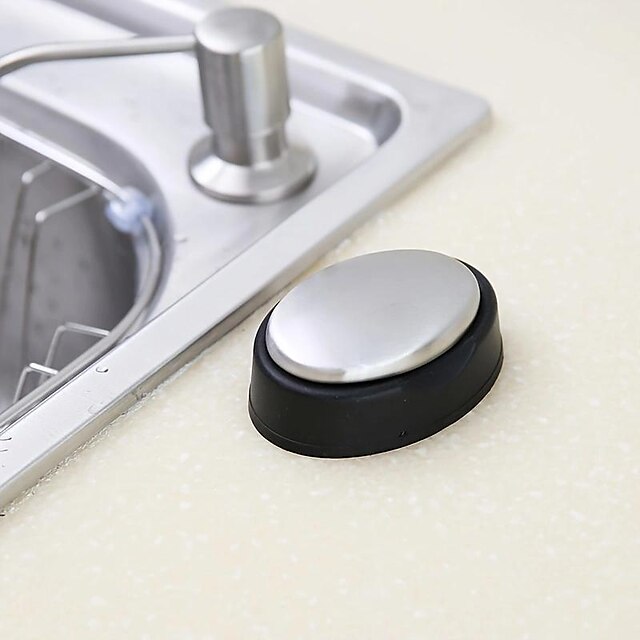 Black and silver magnetic soap holder on a kitchen counter next to a sink.