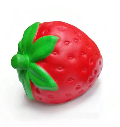 A red strawberry-shaped squishy toy with a green leafy top, photographed on a plain white background.