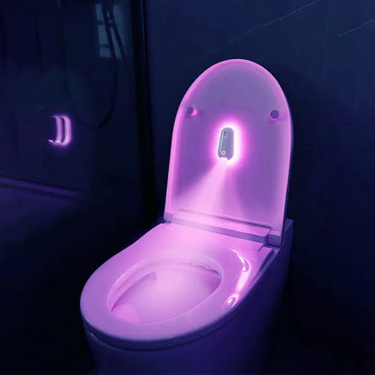 Toilet with glowing purple light in a dark bathroom