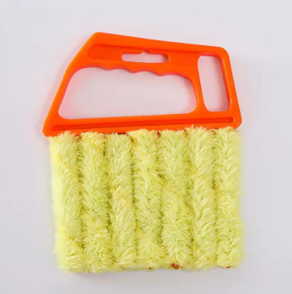 A microfiber cleaning brush with a bright orange plastic handle and light yellow-green fluffy bristles, shown on a plain white background.